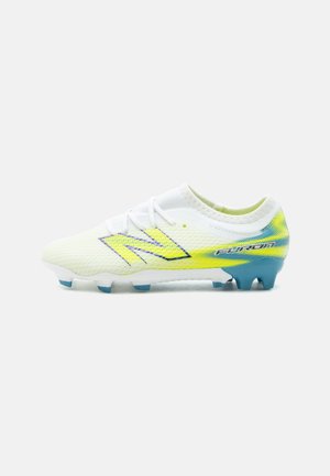 Weiß-gelber New Balance Fußballschuh mit blauen Stollen und „Furon“-Markierung an der Ferse, seitlich gezeigt.
