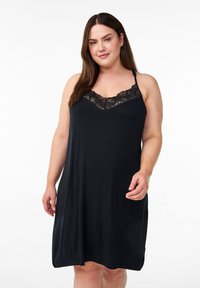 Vestito da notte nero con spalline regolabili, caratterizzato da una rifinitura in pizzo lungo il collo. Tessuto morbido e fluente con una lunghezza fino al ginocchio.