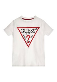 Biela bavlnená tričko s červenou trojuholníkovou grafikou s textom "GUESS U.S.A." a otáznikom, doplnené textom "WASHED JEANS" nižšie.