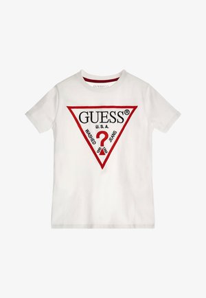 T-shirt en coton blanc avec un graphique triangulaire rouge comportant le texte "GUESS U.S.A." et un point d'interrogation, agrémenté de "WASHED JEANS" en dessous.