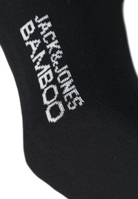 Schwarze Bambussocken mit weißem Text "JACK & JONES BAMBOO." Glatte Textur und schlichtes Design. Keine Muster oder sichtbaren Akzente.