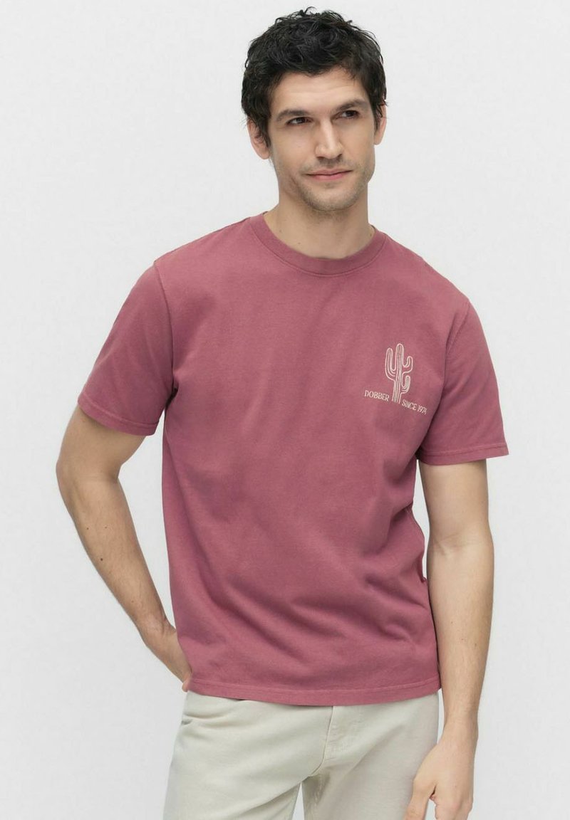 Kortærmet t-shirt med rund hals i støvet rose bomuld. Har et hvidt kaktus grafik på venstre bryst. Blød tekstur, normal pasform.