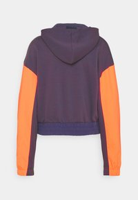 Mikina s kapucí tmavě fialové barvy s jasně oranžovými rukávy. Má elastický lem a manžety. Tkanina vypadá hladká s minimální texturou.