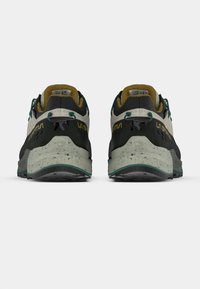 Zapatos de escalada en negro, gris y verde. Cuentan con una suela texturizada, talón reforzado y un logo distintivo en el lateral. Diseño con cordones para un ajuste adecuado.