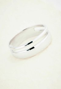 Sølv ring med en glat, poleret overflade. Har to kontrasterende smalle linjer, der omkranser ringens ydre kant.