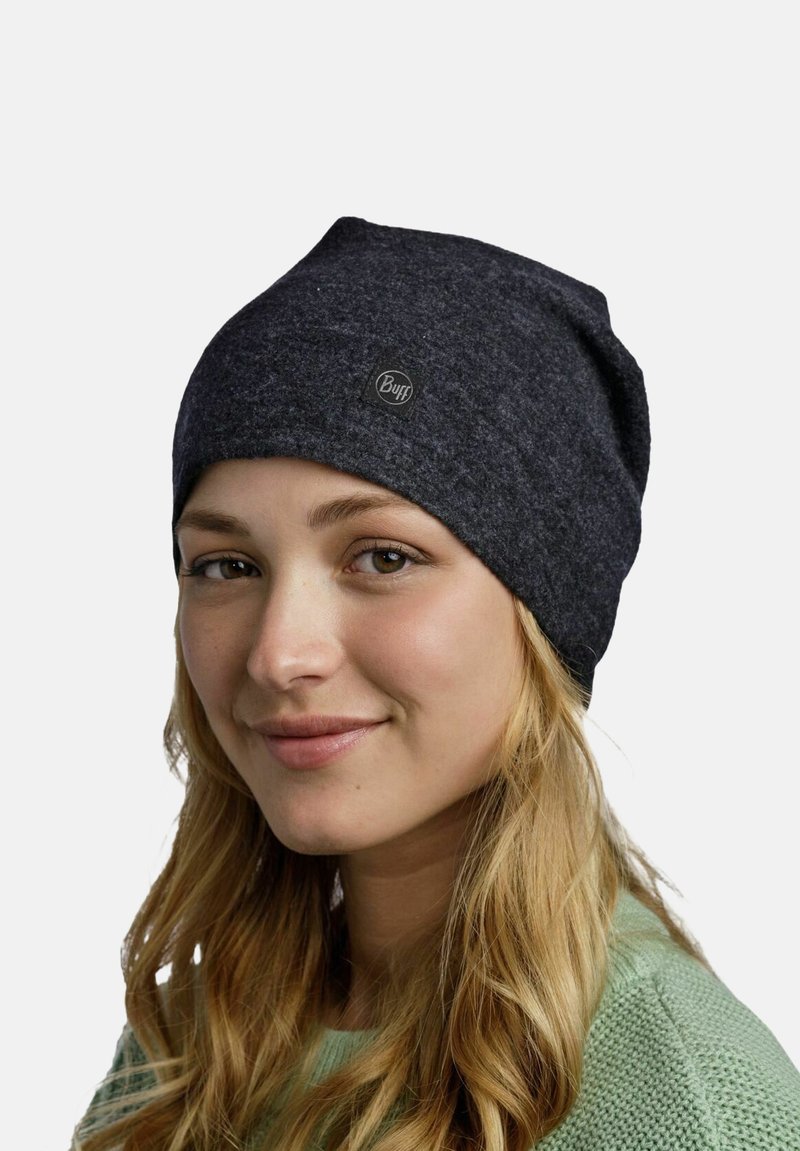 Dark gray knitted beanie with a soft texture, featuring a round Buff logo patch on the front. The hat is close-fitting and slouched.