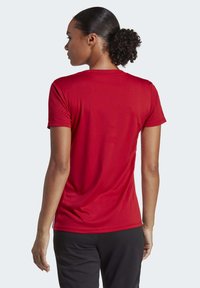 Rode sportieve shirt met korte mouwen, met een gladde textuur en een getailleerd ontwerp. Het shirt heeft een klassieke ronde hals en een licht gebogen onderrand.