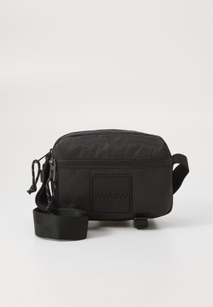 Geantă din material texturat negru, cu formă rectangulară, dotată cu închidere tip fermoar și un logo embosat. Include o cureadetasabilă.