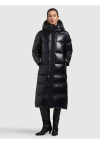 Lång, svart dunjacka med blank yta, huva, dragkedja framtill och sidofickor. Har vadderade sektioner för isolering.