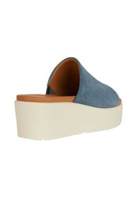 Scarpa slip-on in suede blu con forma arrotondata, fodera interna color beige e suola spessa in gomma bianca. Presenta una texture liscia.