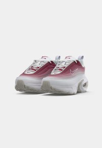 Tenisky Nike Air Max s gradientovým ružovým zvrškom, bielou strednou podrážkou, textúrovanou gumovou podrážkou a výrazným brandingom Nike na jazyku.