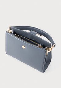 Smaiga pelēka soma, izgatavota no gludas mākslīgās ādas, ar zelta rāvējslēdzēju, zelta pogas akcentu un īsu rokturi ērtai nēsāšanai.