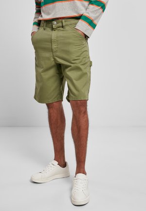 Olive green cargo shorts in cotton blend, featuring side pockets and a relaxed fit, paired with white sneakers and a striped long-sleeve shirt.