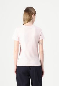 Lys rosa bomull t-skjorte med korte ermer og rund hals, med en glatt tekstur og et enkelt design.
