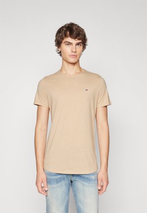 Camiseta de manga corta beige hecha de material de algodón suave. Cuenta con un cuello redondo y un pequeño parche de logo en el pecho.