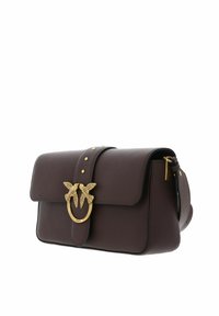 Sac à main en cuir marron foncé avec un rabat, une ferrure dorée en forme d'oiseau et des clous décoratifs, doté d'une bandoulière amovible.