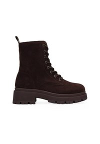 Botas de tobillo de ante marrón con suela de goma gruesa, diseño con cordones, ojales metálicos y una lengüeta detrás para ponerlas y quitarlas fácilmente.