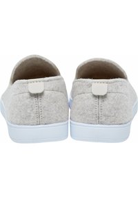 Chaussures slip-on grises avec des semelles en caoutchouc blanches. Elles présentent une petite étiquette blanche à l'arrière et une couture discrète à l'arrière. Surface texturée.