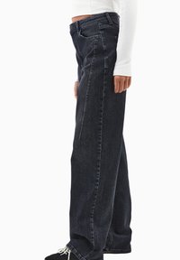 Granatowe dżinsy w luźnym fasonie, prosta nogawka i widoczne szwy boczne. Posiada standardowe szlufki na pasek oraz tylne kieszenie.
