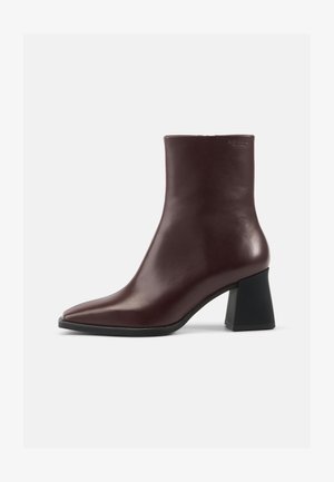 Botas de tornozelo em couro borgonha com bico apontado, textura suave e um salto grosso preto. Design elegante, com acentos mínimos.