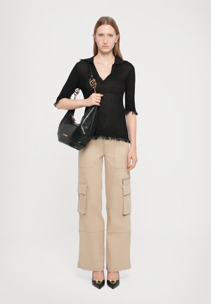 Black knit top with a collar and frayed edges, paired with beige cargo pants featuring pockets and zippers, and black pointed-toe heels.