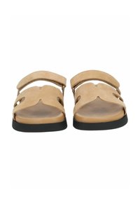 Sandali in suede beige con due ampie cinghie, design con ritagli e suola in gomma nera. Soletta piatta con uno stile minimalista.