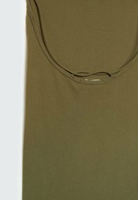 Gros plan sur un débardeur côtelé vert olive, montrant un col arrondi et la texture du tissu.