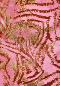 Tejido texturizado con un fondo rosa y patrones de rayas de tigre en oro y bronce. El diseño tiene un acabado brillante y metálico.