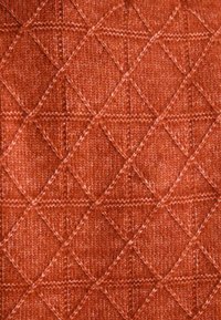 Tekstuuriga kangas, millel on harmooniline rombikujundus soojas, roostes oranžis värvitoonis, sisaldades peeneid tooni ja niidi detaile.