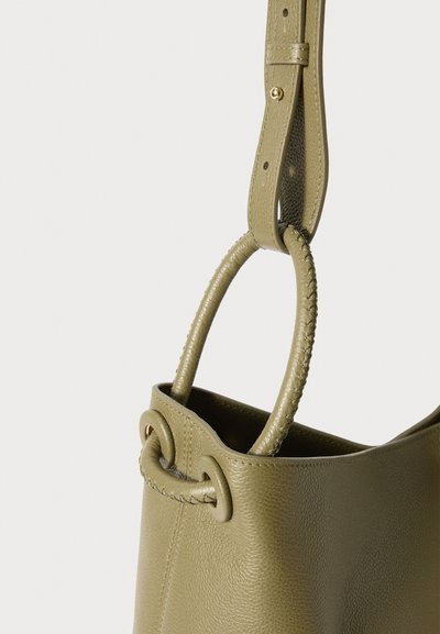 Grüne Ledertasche im Eimer-Design mit strukturierter Oberfläche, ausgestattet mit einem geflochtenen Griff und einem glatten Tragegurt. Abgerundeter Deckel mit subtilen Nähten.