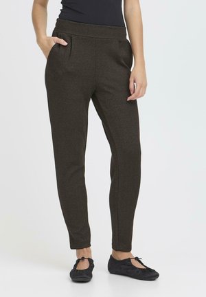 Pantalones de espiga marrones con cinturilla elástica, bolsillos frontales, corte ajustado, combinados con bailarinas negras.