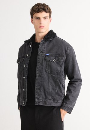 Zwarte denimjack met een faux shearling kraag. Voorzien van twee borstzakken, knoopsluiting aan de voorkant en een klassieke pasvorm. Geweven, stevig materiaal.