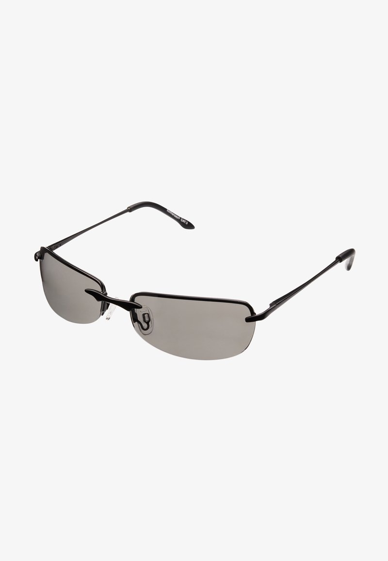 Lunettes de soleil avec une monture en métal noir léger, des verres teintés gris et des branches fines. Le design notable comprend une forme minimaliste et des plaquettes de nez transparentes.