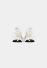 Weiße und graue Sportschuhe mit einem Mesh-Obermaterial, gepolsterter Sohle und strukturiertem hinteren Teil. Verfügt über eine Zuglasche und eine schwarze Gummisohle.