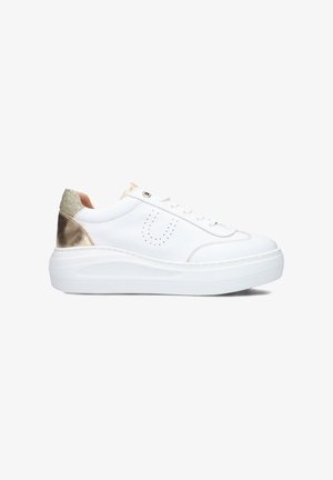 White leather sneaker with gold accents on the heel, round toe, flat white sole, and perforated design on the side.