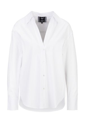 Chemise blanche à manches longues avec col et boutonnière, ourlet légèrement arrondi, présentée sur un fond blanc uni.