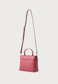 Borsa a mano strutturata in pelle rossa con tracolla staccabile, manico superiore e ferrature color oro. Texture liscia e design minimalista.