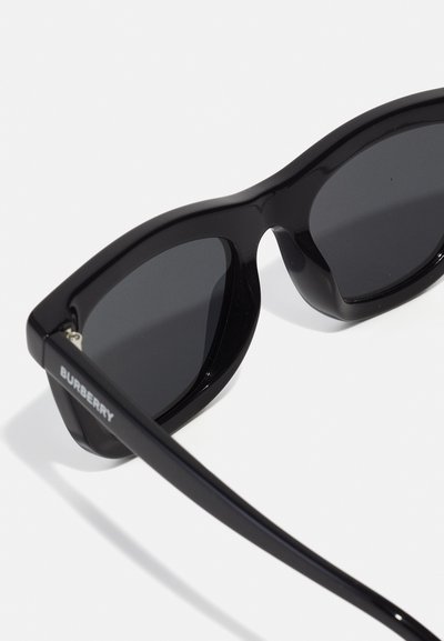 Černé sluneční brýle s robustním plastovým rámem a tmavými skly. Na straně se nachází značka "BURBERRY". Hladký povrch a ostrý design.