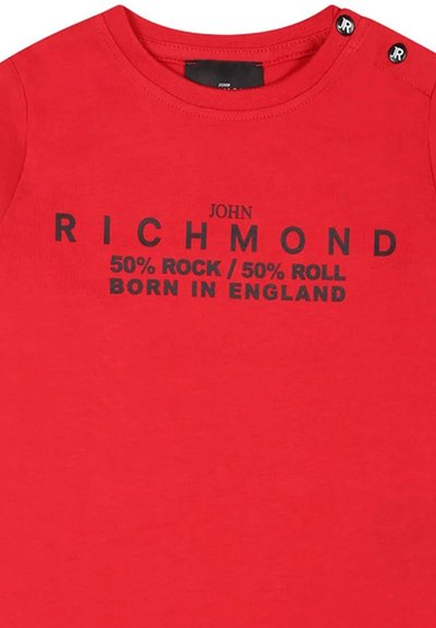 T-shirt corta rossa in cotone con testo nero: "JOHN RICHMOND 50% ROCK / 50% ROLL NATO IN INGHILTERRA" con due bottoni sulle spalle.