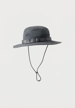 Chapeau d'extérieur à large bord gris foncé avec cordon de menton réglable et logo The North Face sur le côté, conçu pour la protection solaire.