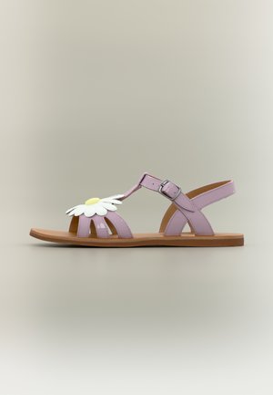 Lilac flat sandal with ankle strap, buckle closure, brown sole, and decorative white and yellow daisy on the front straps.