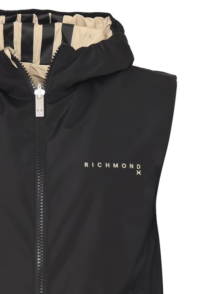 Giubbotto smanicato nero con cappuccio, presenta una zip dorata e un logo. L'interno ha una fodera beige a contrasto con strisce nere.