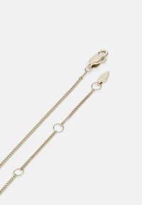Goldfarbene Kettenaccessoire mit einem Karabinerhaken, kreisförmigen Gliedern und länglichen Segmenten für anpassbare Länge. Glatte Textur und elegantes Design.