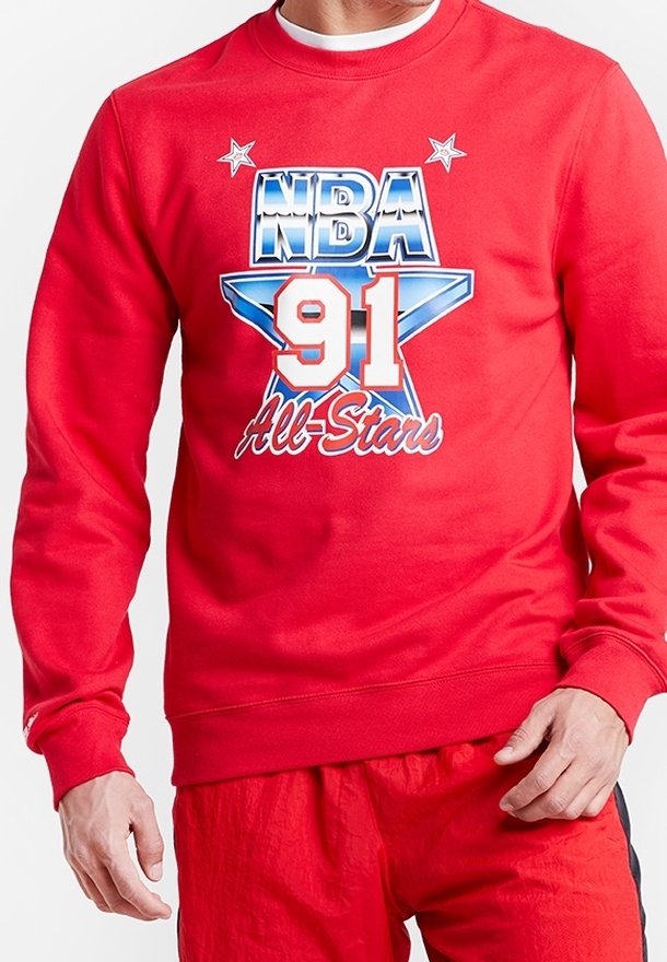 Sweat-shirt rouge présentant un graphique NBA 91 All-Stars avec des accents d'étoiles bleues et blanches. Fabriqué en tissu texturé avec des manches longues.