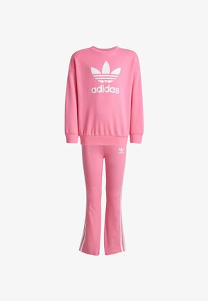 Sweatshirts et pantalons en coton rose, ornés du logo blanc d'adidas et de trois bandes. Les enfants portent des baskets blanches avec des accents noirs.