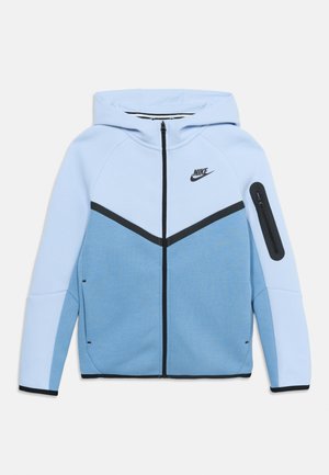 Lyseblå Nike lynlåstrøje med sort lynlås foran, sort lynlås på armen og sort logo på brystet.