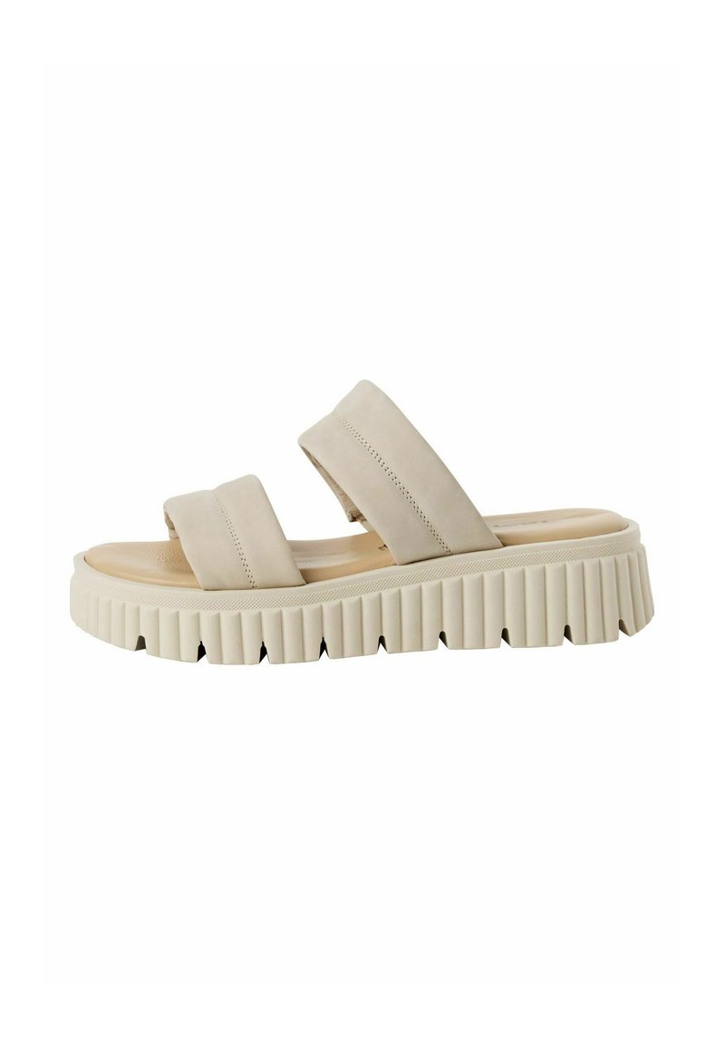 Beige slidesandal med två breda remmar, formad fotbädd och tjock räfflad sula. Materialet ser mjukt ut och har en slät yta.