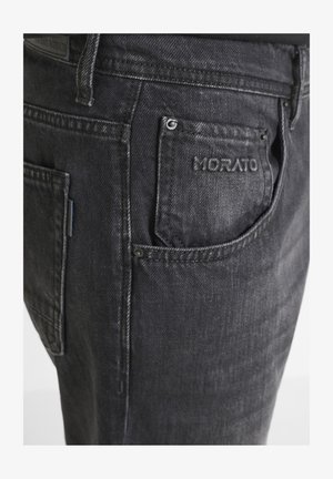 I jeans in denim neri presentano una vestibilità slim, cuciture a vista, una tasca con il marchio "MORATO" in rilievo e accenti di texture scolorita.