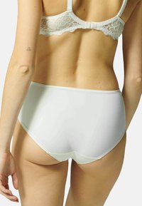Witte high-waisted onderbroek met een gladde afwerking, voorzien van minimale stiksels en een zachte textuur, gecombineerd met een met kant afgewerkt bh.