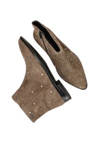 Bruine suede enkellaarzen met puntige neuzen, zilveren studs als detailing en een zwarte platte zool. Rits aan één kant.